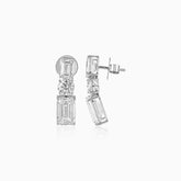 Diamond earrings with emerald-cut and round stones in geometric vertical arrangement